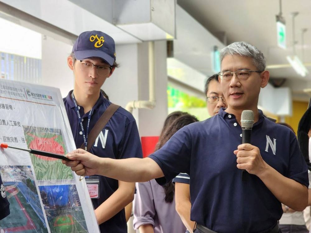 《圖說》侯友宜視察興穀國小操場共構地下停車場工程完工現況，新工處長簡必琦(右)在場簡報說明。〈工務局提供〉