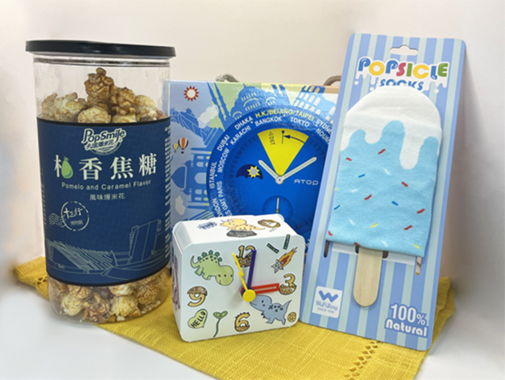 《圖說》適合親子家庭的「童趣探險包」，內含有卡滋爆米花觀光工廠樂園的柚香焦糖爆米花、王鼎時間科藝體驗館的時鐘DIY材料包及吳福洋襪子故事館的冰棒造型短襪。〈經發局提供〉