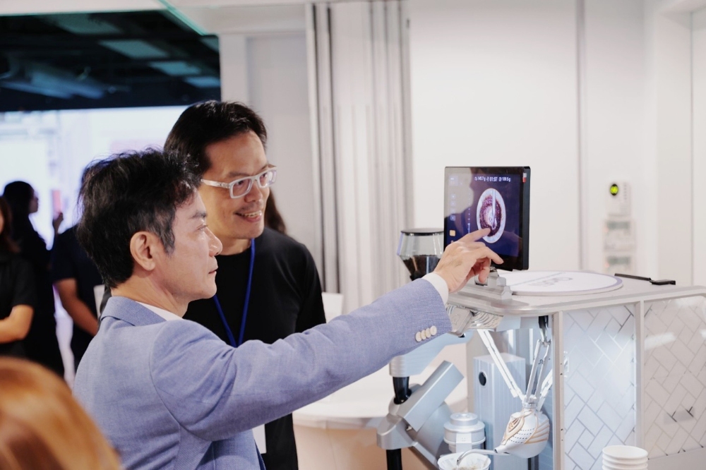 ▲資策會董事長黃仲銘(圖左)親自體驗AI手沖咖啡，讓喝咖啡也可以很「科技」。(圖/資策會提供)