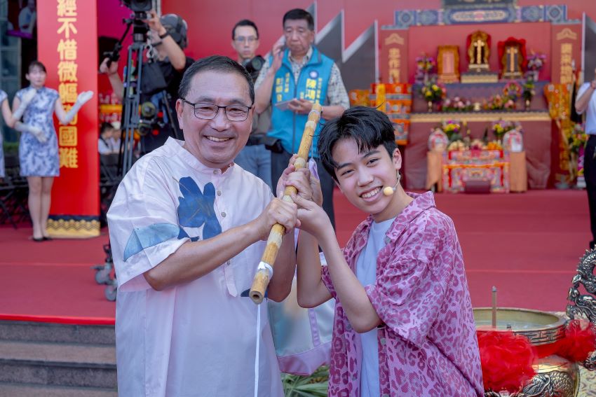 市長侯友宜與JHall主唱子濬交接擔頭代表客家文化代代相傳、生生不息的精神。〈客家局提供〉