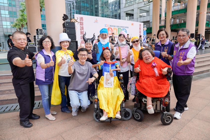 有些障礙看不見 卻真實存在 1 《圖說》新北市身心障礙綜合成果展今日登場,市府副秘書長張其強(灰衣者)及社會局長李美珍(右2)與表演者合影,左二副局長許秀能。〈社會局提供〉