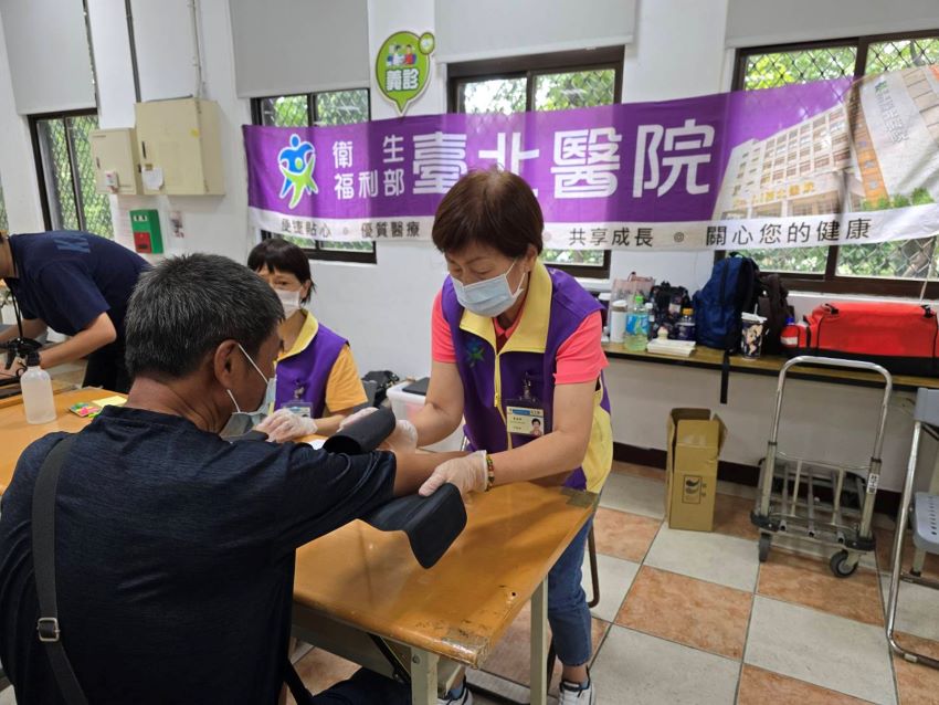 月餅之外的處方籤 臺北醫院中秋義診街友倍感溫暖 5 《圖說》臺北醫院志工為街友量血壓。〈臺北醫院提供〉