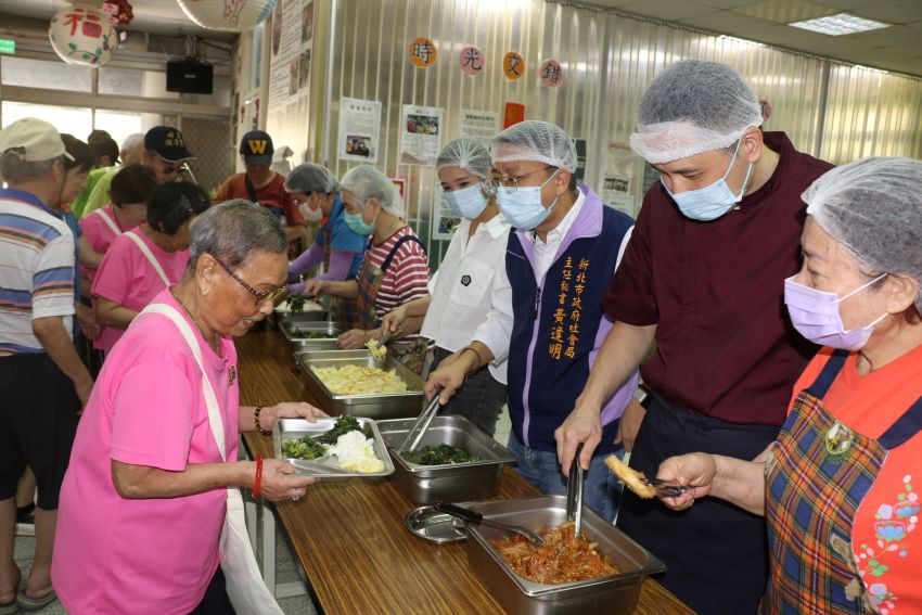 惜食分享廚房開伙 五星級主廚陳佳瑋為長輩掌廚 6 《圖說》社會局主任秘書黃逢明〈右三〉和陳佳瑋義廚(右2)為長輩打菜。〈社會局提供〉