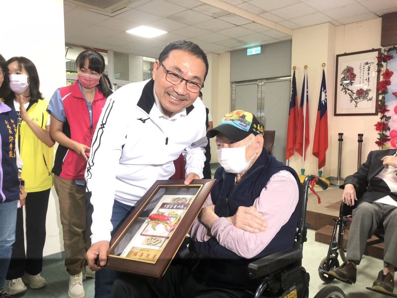 《圖說》侯友宜市長致贈99歲新北敬老獎牌。〈板橋公所提供〉