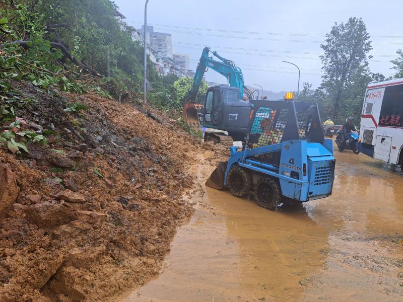 《圖說》新北市連日豪大雨,汐止區伯爵山莊2期擋土牆坍塌,造成康寧街與福德一路口出現土石滑落,養工處及汐止區公所全力搶修。〈工務局提供〉