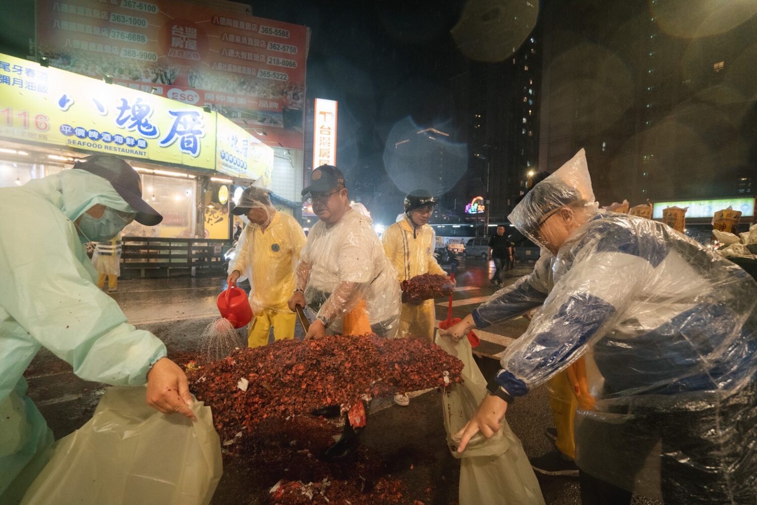 大雨加深路面清掃難度，但志工們用力剷鞭炮餘灰維持香路ESG。（圖／桃園護國宮提供）