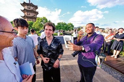Photo shows a foreign tourist photographing a tourism brochure at the tourist service center in Quanzhou.