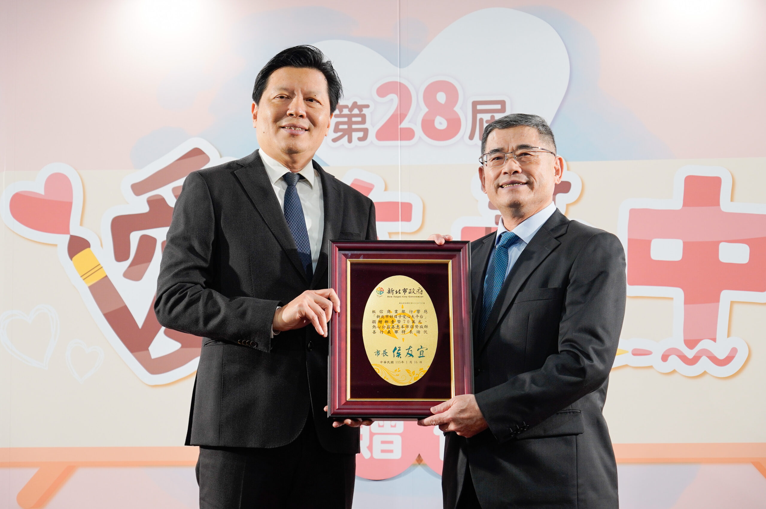 《圖說》板信商業銀行總經理曾學智(右)代表捐贈70萬元支持「愛在畫中」計畫，副市長朱惕之(左)頒贈感謝牌，感謝板信商銀多年來攜手市府推動公益。〈社會局提供〉