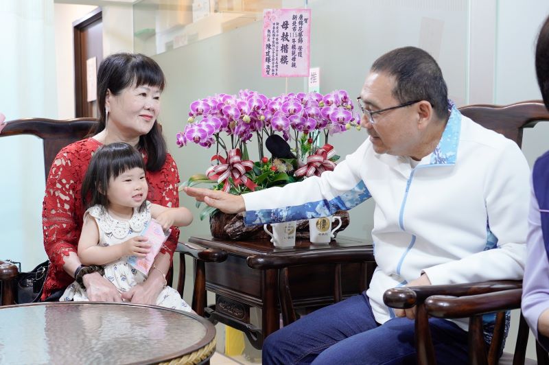 《圖說》康錦花孫女學說話第一句叫「阿嬤」，令她相當開心，平時也會學阿嬤針灸手勢，侯友宜市長誇小孫女靈巧。〈社會局提供〉