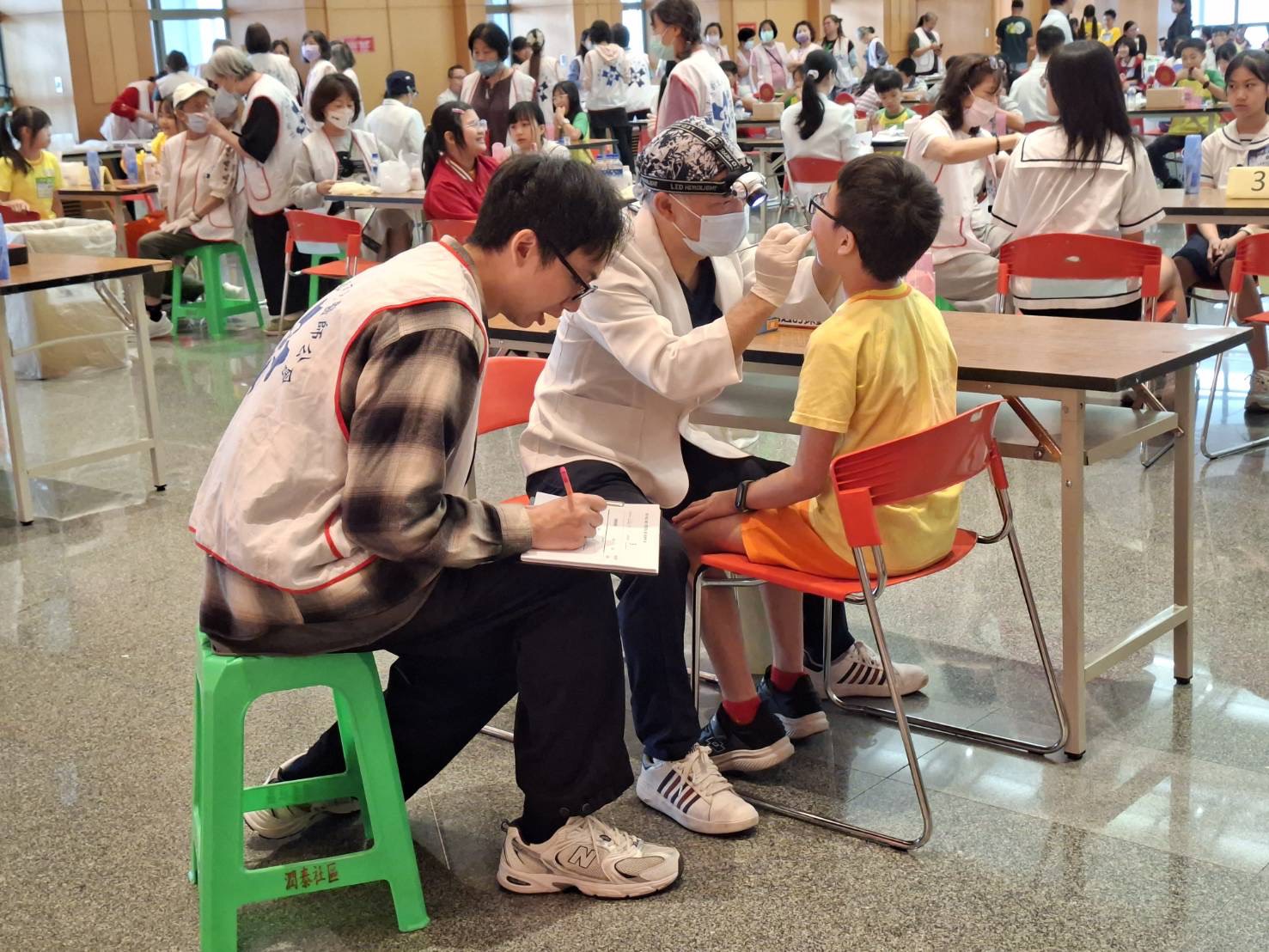 《圖說》「2026年新北市國小學童潔牙比賽—刷牙小英雄 拒檳護齒大作戰」，牙醫師詳細檢查參賽學童潔牙情形。〈衛生局提供〉