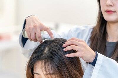 A Kolmar Korea researcher tests ‘scalp sun essence’ formulation.