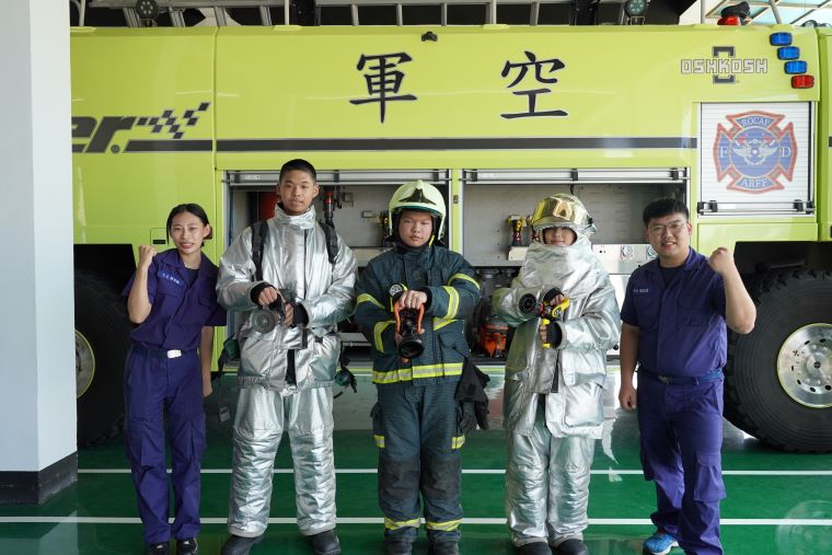《圖說》參訪空軍松山基地指揮部消防分隊，青年初次穿上消防服體驗裝備之沉重與不易，直呼體驗有趣且印象深刻。〈社會局提供〉