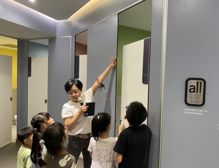 《圖說》台灣伴侶權益推動聯盟秘書長簡至潔向孩子導覽性別友善廁所。〈社會局提供〉